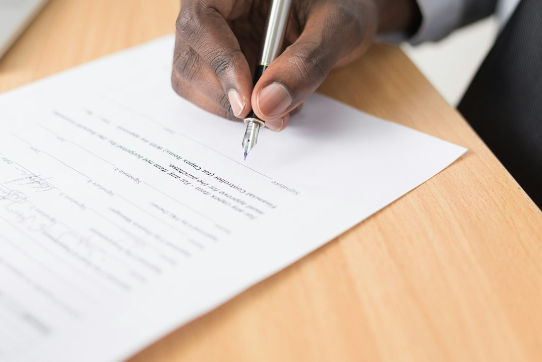 Person reviewing and signing a document at a desk