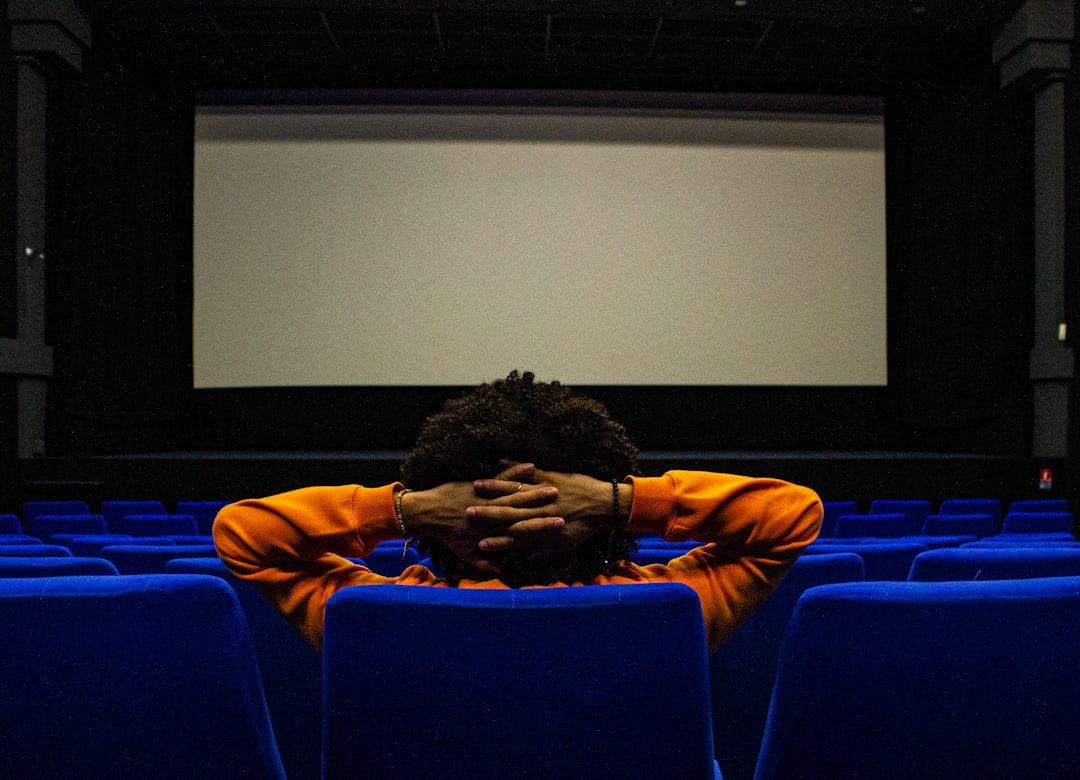 Audience member facing a cinema screen; illustrative stock image, not a scene from The Flood