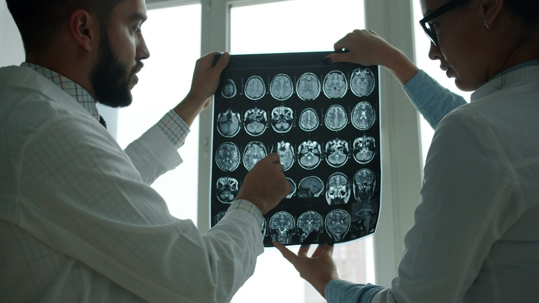 Two clinicians studying medical scan images in a hospital, illustrative photograph