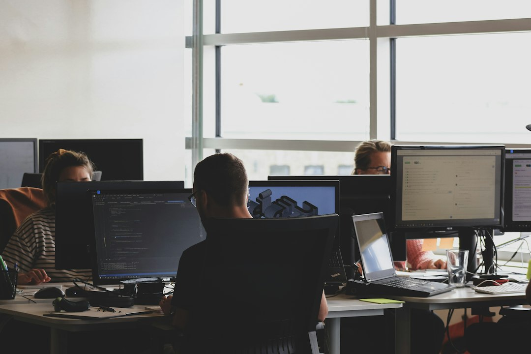 Cybersecurity professionals working at computer monitors in an office