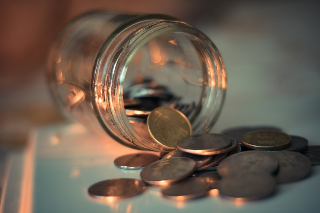Clear glass jar containing coins for savings