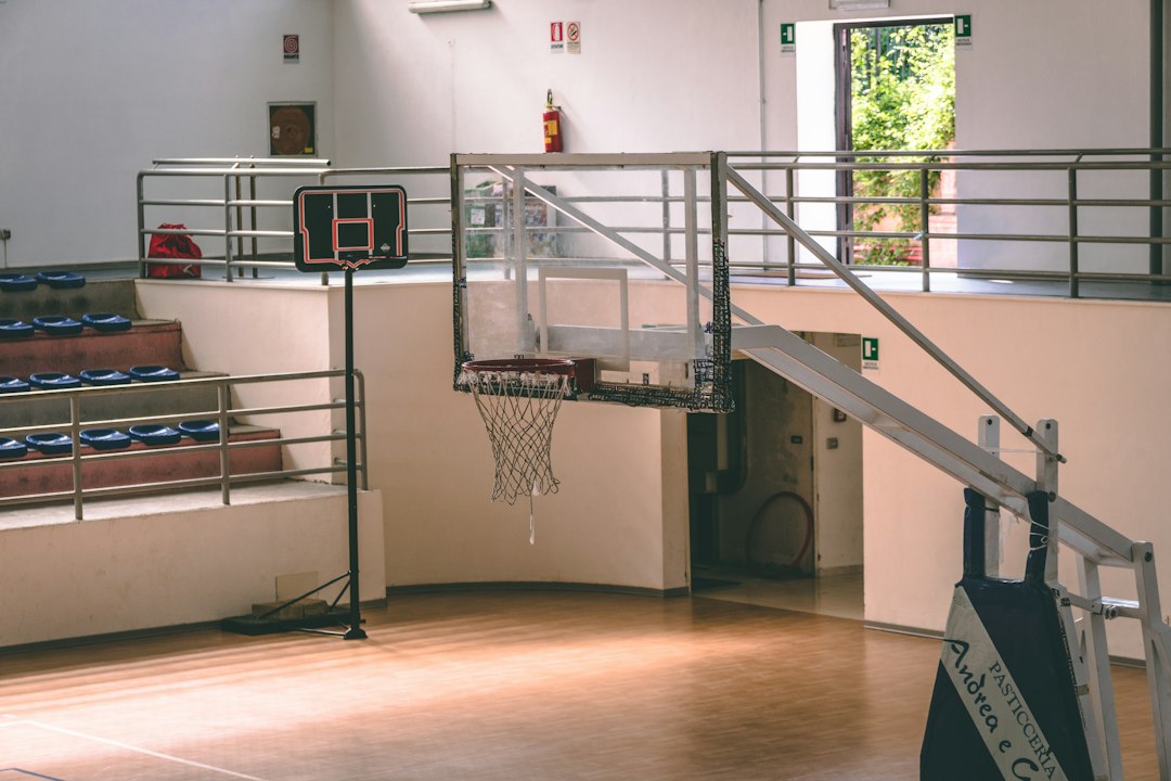 Empty indoor basketball court and hoop; illustrative image for 76ers training camp story