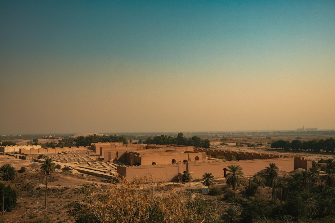 Ancient Iraqi ruins and palm trees at sunset, illustrative image