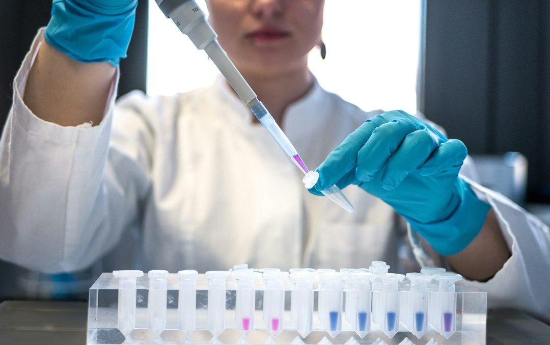 Researcher pipetting liquid in a laboratory, illustrative photograph