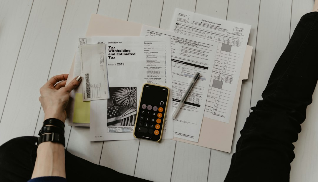 A person reviewing financial documents with a calculator and pen