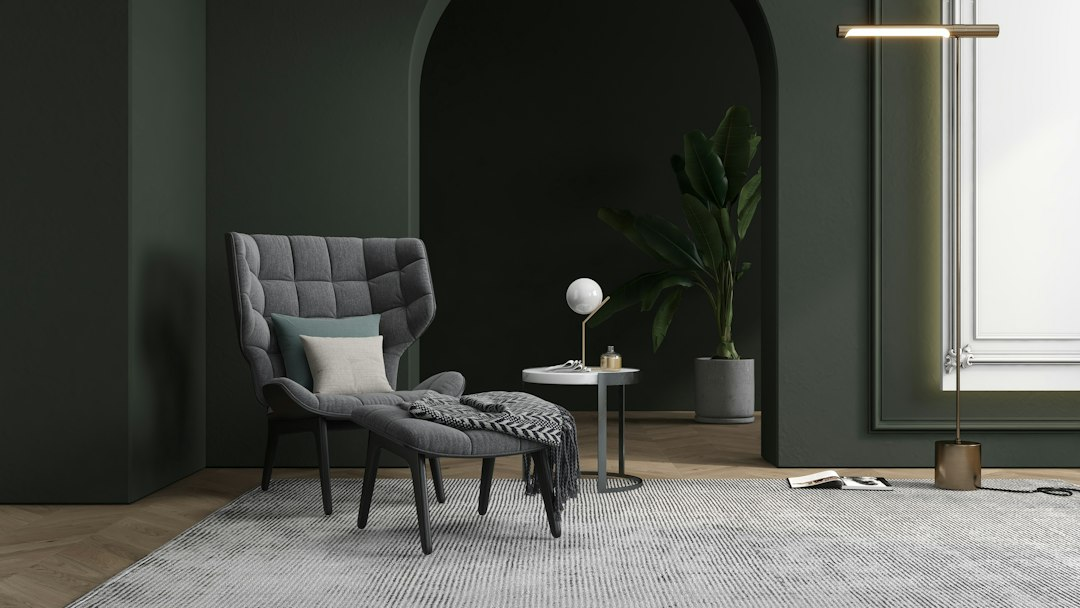 Gray armchair and ottoman in a dark green living room