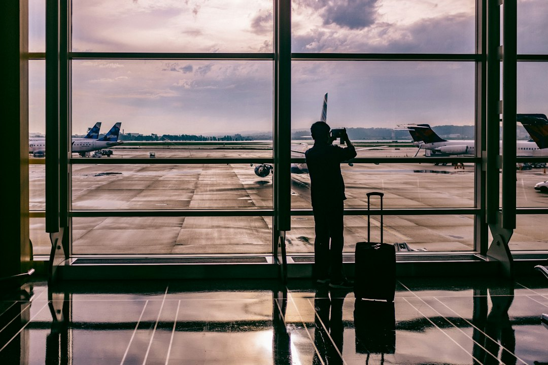 A traveler using a smartphone near an airplane