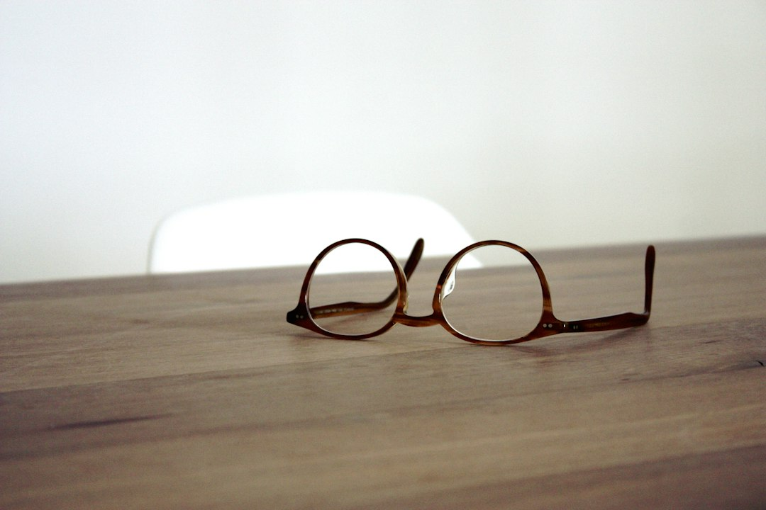 A pair of eyeglasses resting on a wooden surface