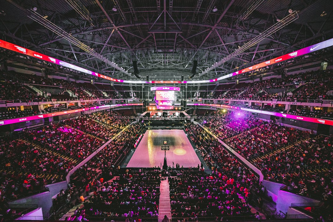 A basketball game being played inside a crowded arena