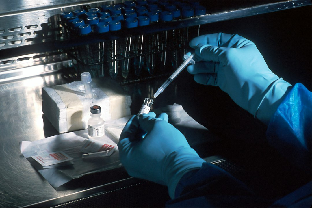 Scientist preparing material under a sterile laboratory hood for cancer research