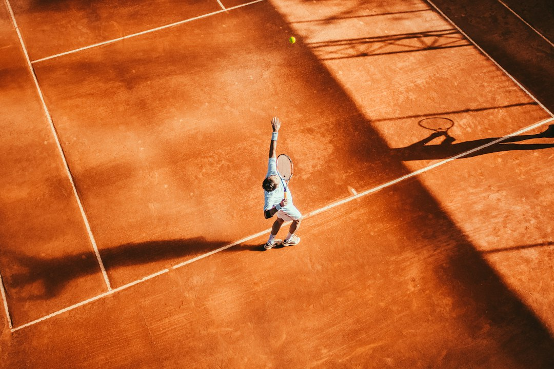 Tennis player preparing to return a shot on an outdoor court, illustrating the Japan Open
