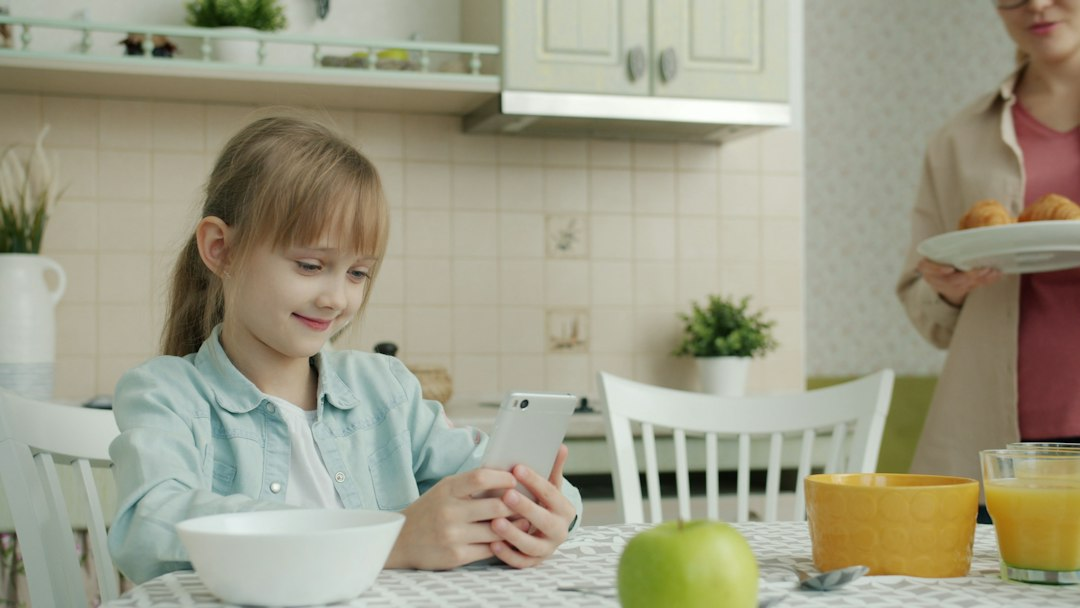 Parent and child with a smartphone at home; illustrative image