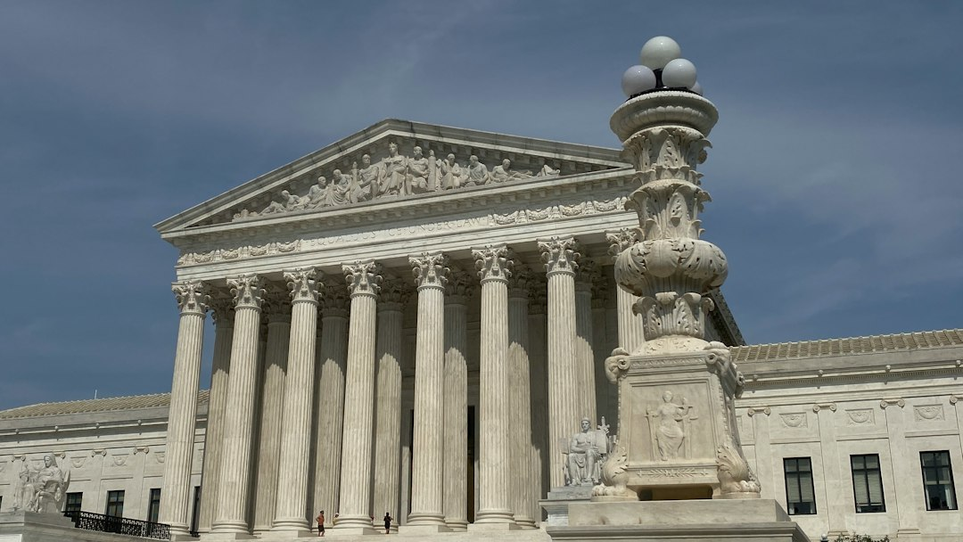 Columned federal court building in Washington, D.C., under a blue sky
