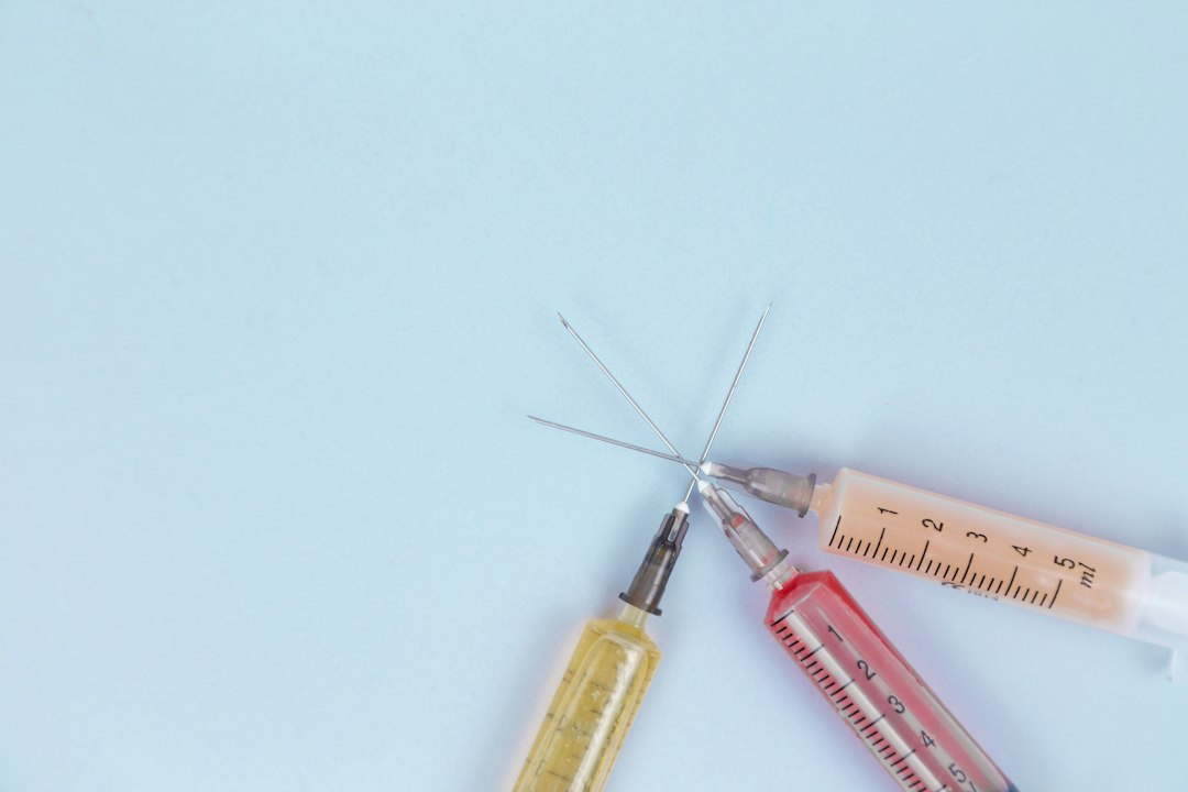 Syringes and injectable medicines arranged on a blue surface, illustrating a drug recall