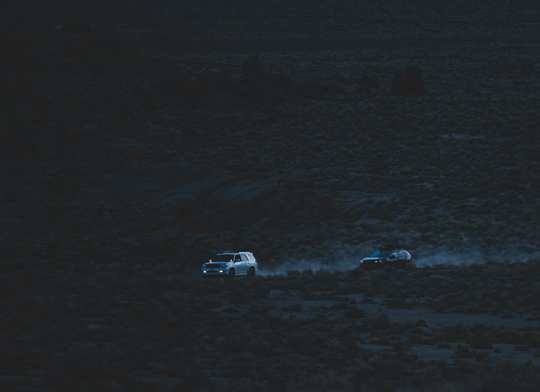 Illustrative vehicles traveling on a rain-soaked road at night
