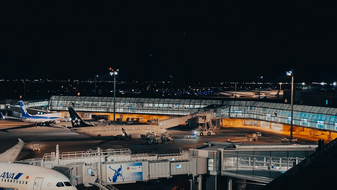 Commercial aircraft parked at an illuminated airport terminal at night