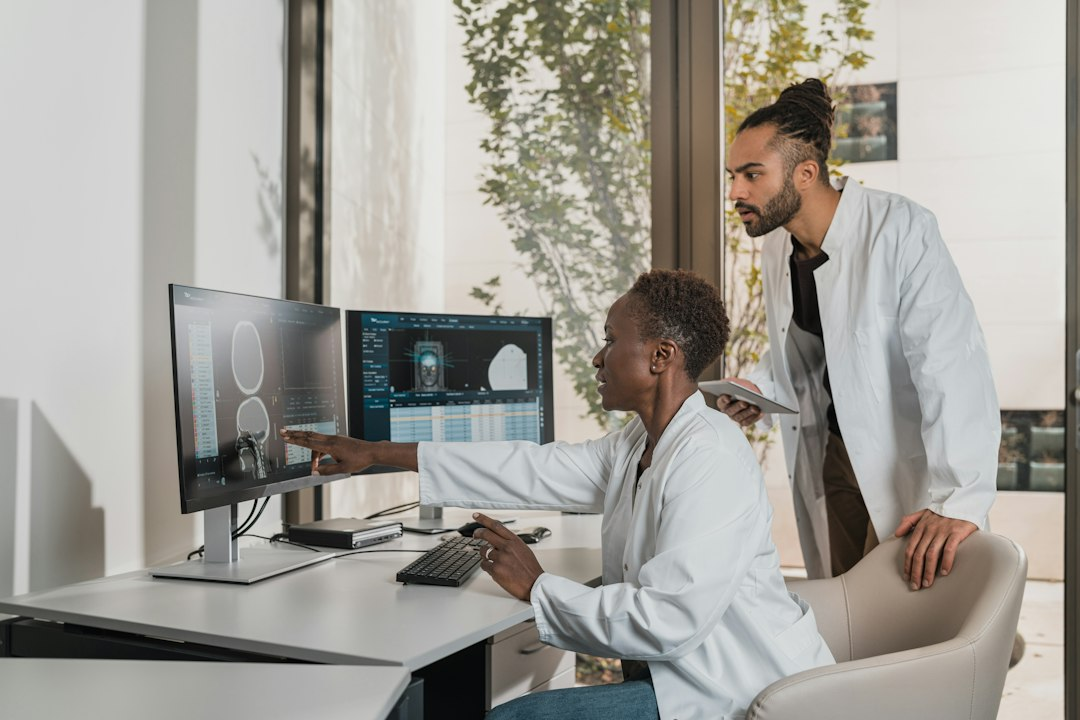 Medical professionals reviewing brain scans on computer monitors