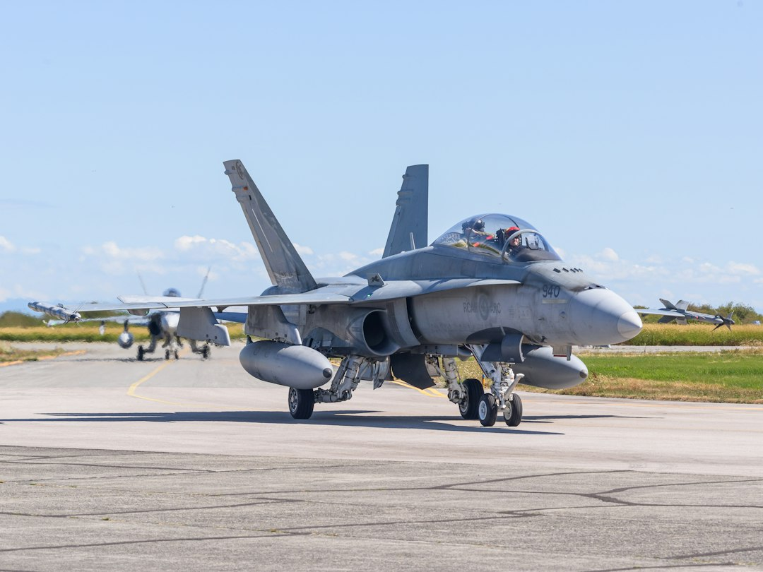 Two military fighter jets taxiing on a runway after an airshow