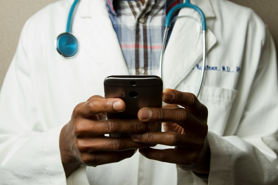 Clinician holding a smartphone in a healthcare setting, illustrating mobile point-of-care ultrasound