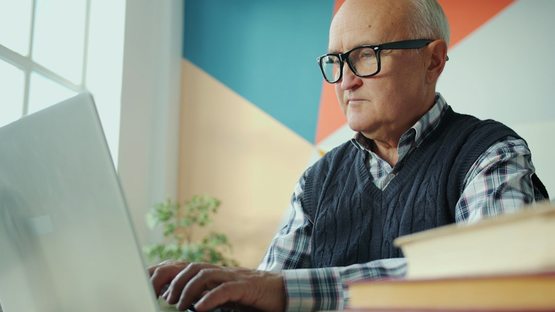 Older adult reviewing information on a laptop at home