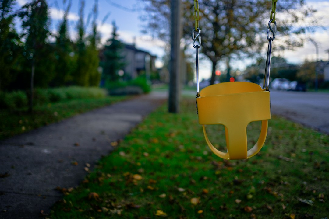 An empty yellow child swing seat in a neighborhood, illustrative of the PACEARTH recall