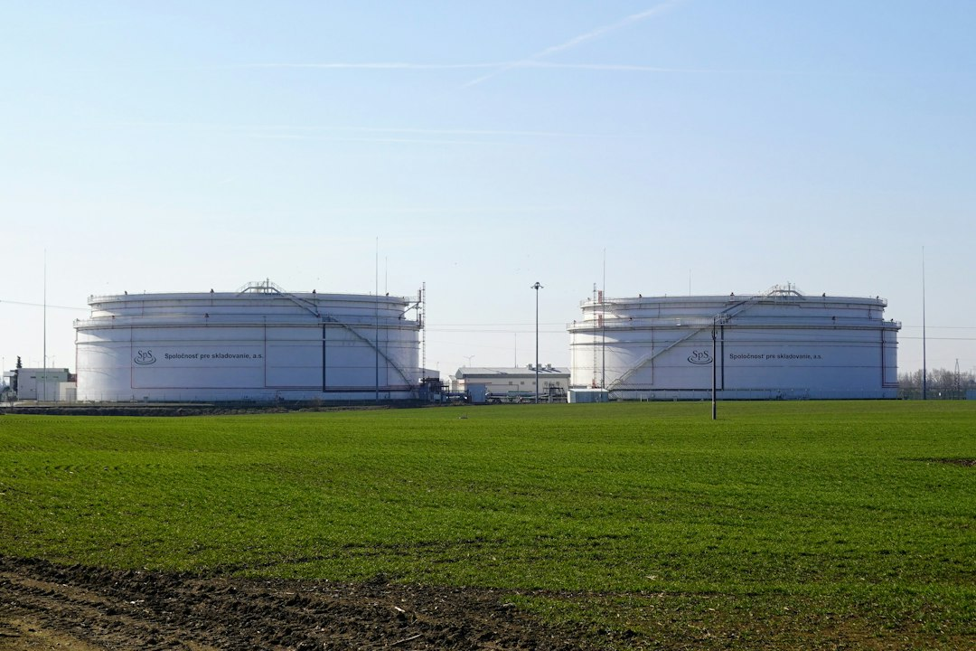 Large petroleum storage tanks beside a green field