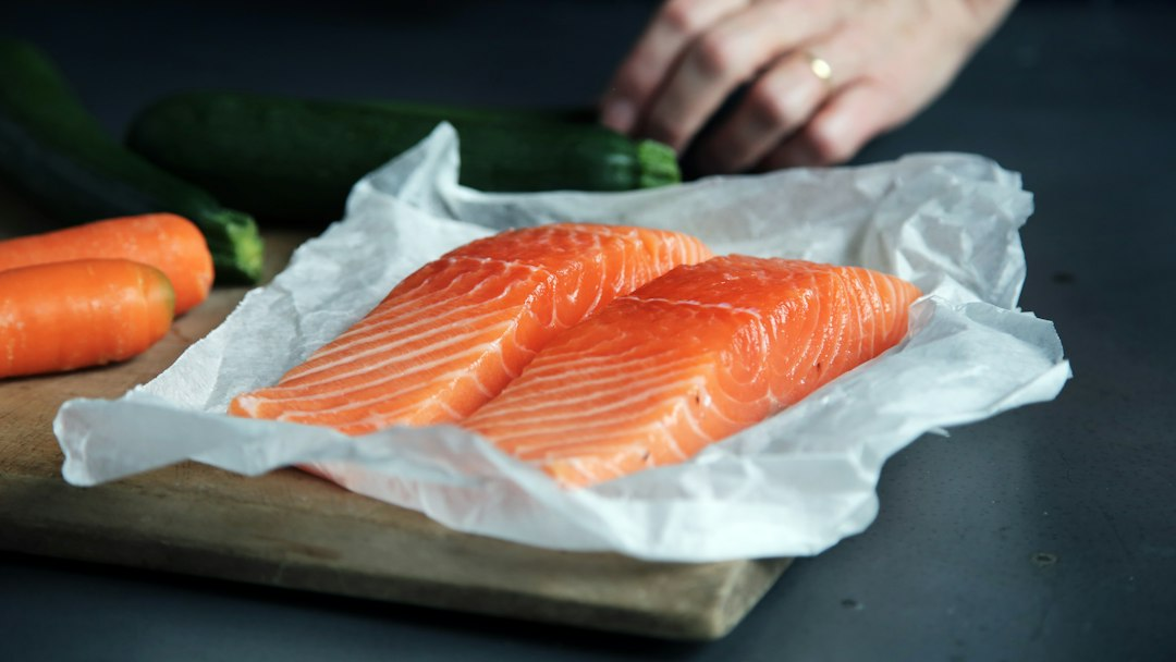 Raw salmon portions on a wooden cutting board, illustrating the Starfish smoked salmon recall