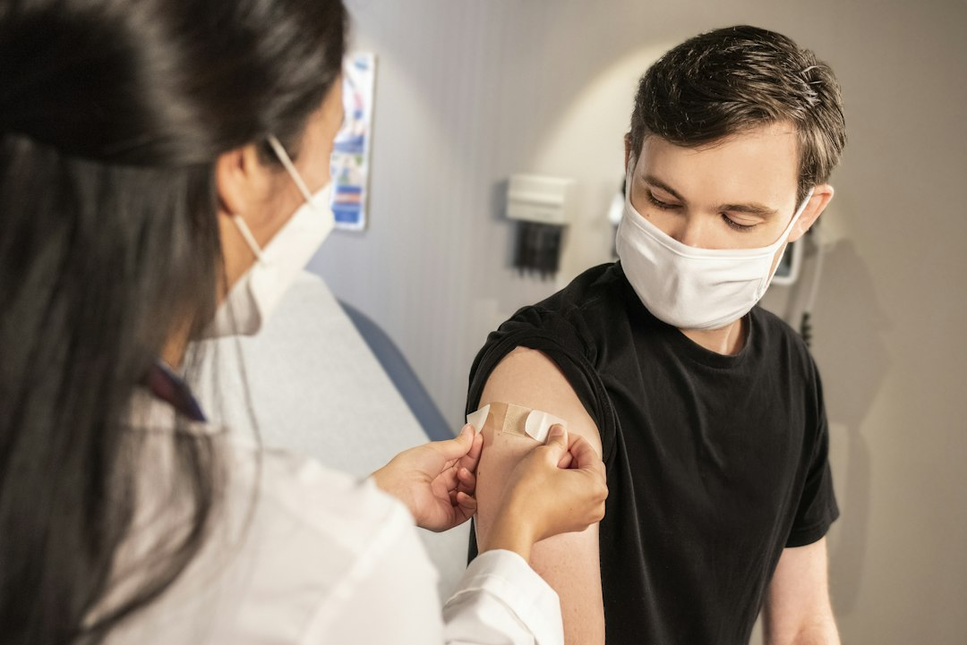 Healthcare provider placing a bandage after administering a vaccine