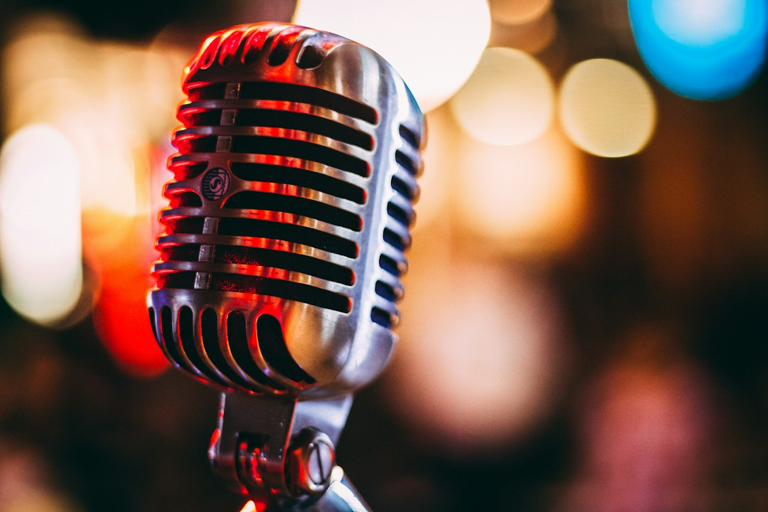 Singer performing into a microphone under stage lights