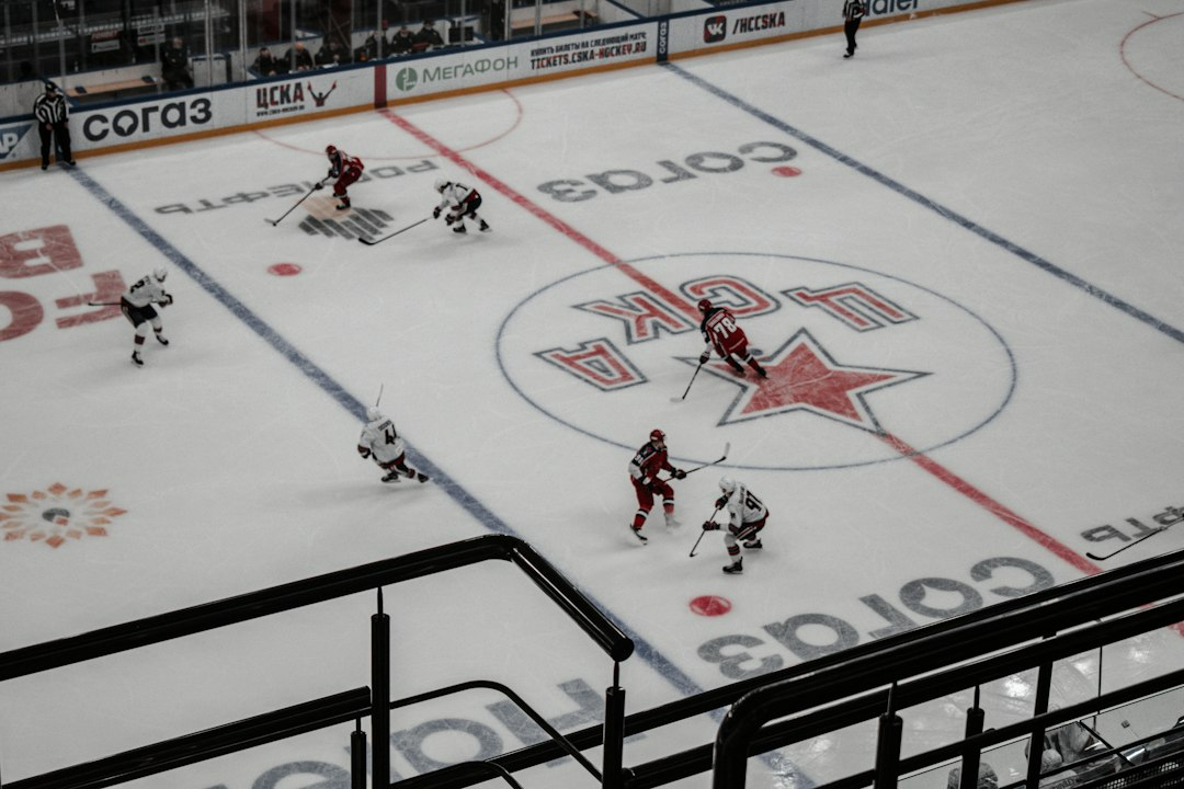 Ice hockey players competing near the boards on a rink